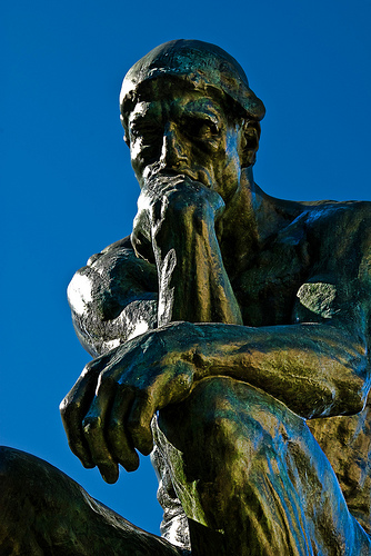 Estatua de un hombre pensando vista desde abajo.