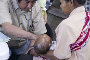 médico atendiendo a un niño en brazos de su madre.