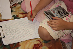 Chico con libreta y calculadora haciendo anotaciones